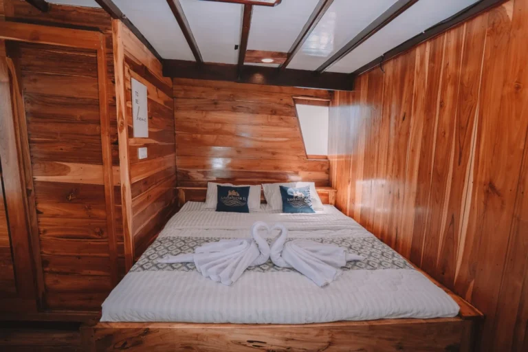 Interior view of Vip cabin on Andalucia phinisi, showcasing wooden decor and bed.