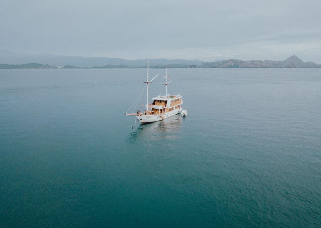 The Gandiva Phinisi boat anchored in calm waters of Komodo National Park.